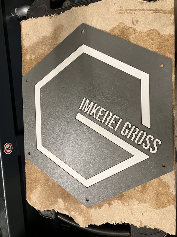 Fertige Intarsie Imkerei Gross, graue Fliese mit weißem Logo