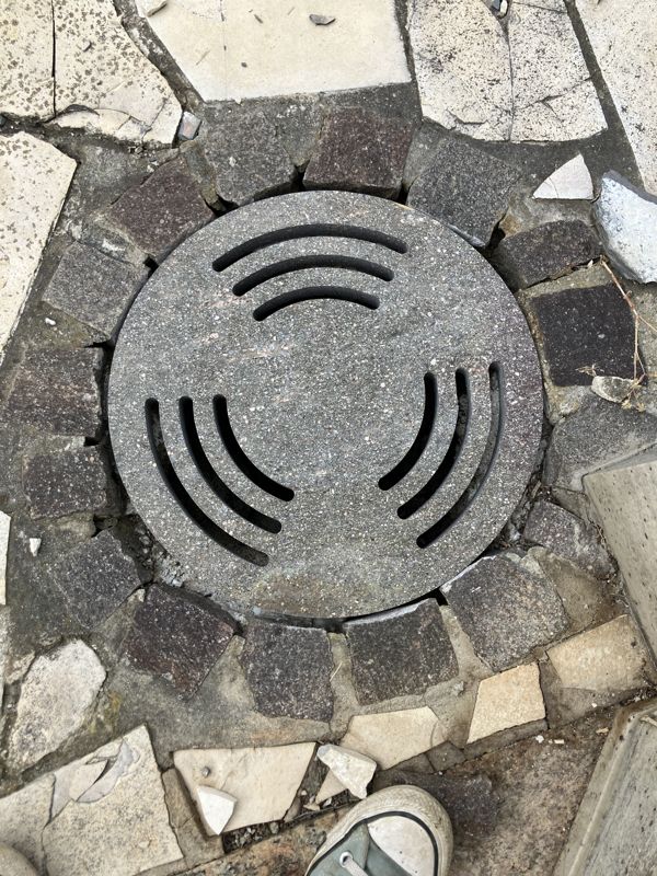 Runde Steinplatte mit Bogenschlitzen im Mosaikweg
